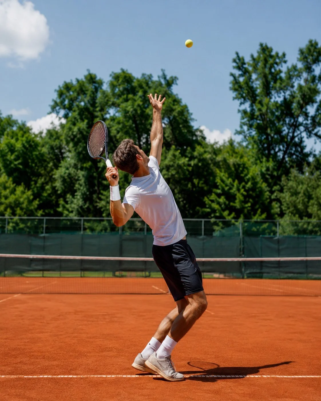 Tennisspieler beim kontrollierten Aufschlag am hohen Treffpunkt